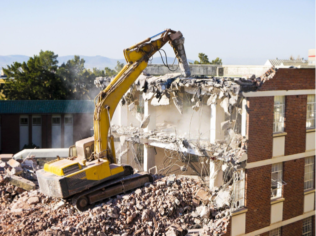 مقاول هدم مباني محترف يرتدي معدات السلامة أثناء عملية الهدم
